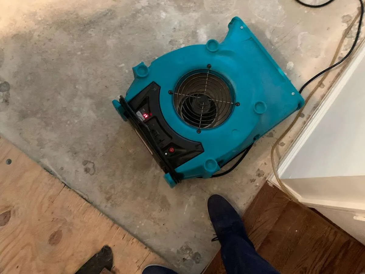 Air mover drying subfloor during Commercial Water Damage Restoration in Angola
